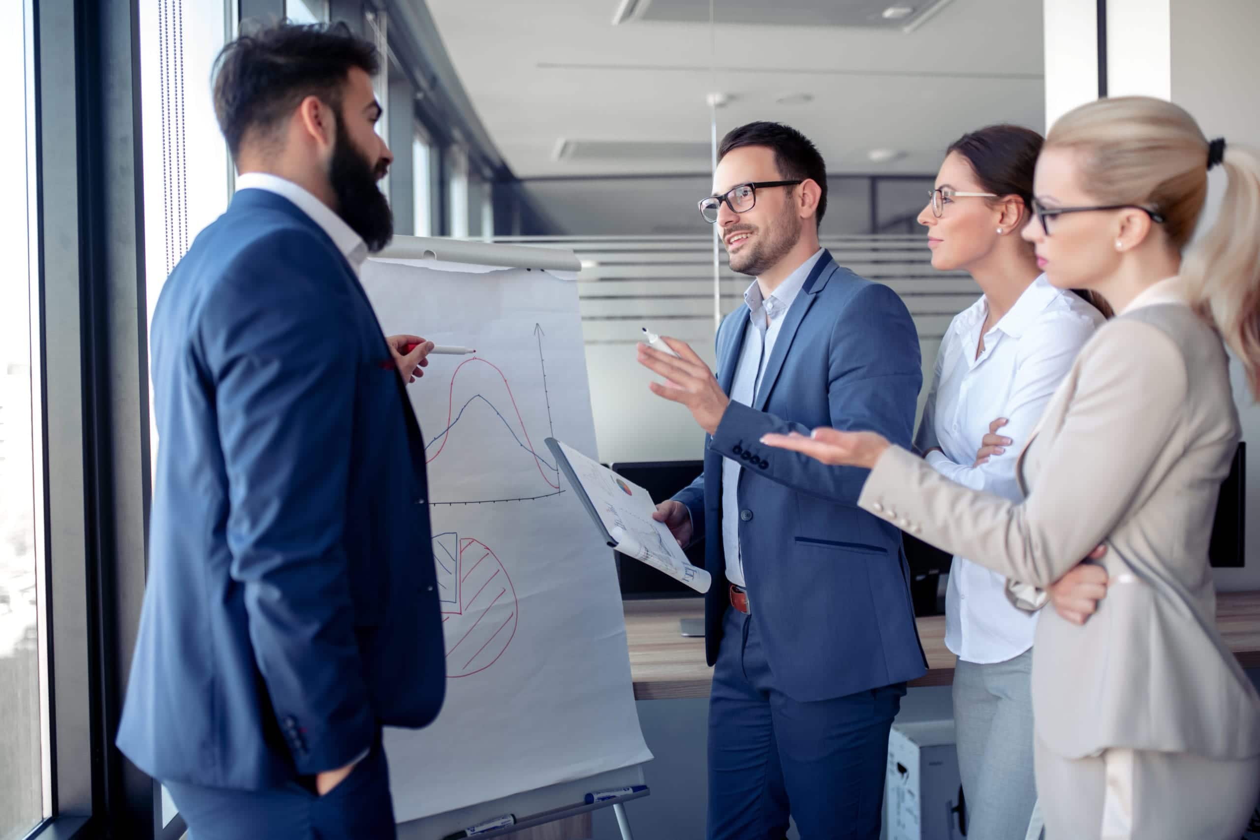 Portrait of a young businessman giving presentation to his colleagues in a office.